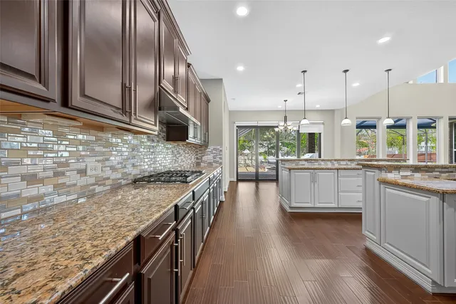 a view of a kitchen with a sink stainless steel appliances and a chandelier