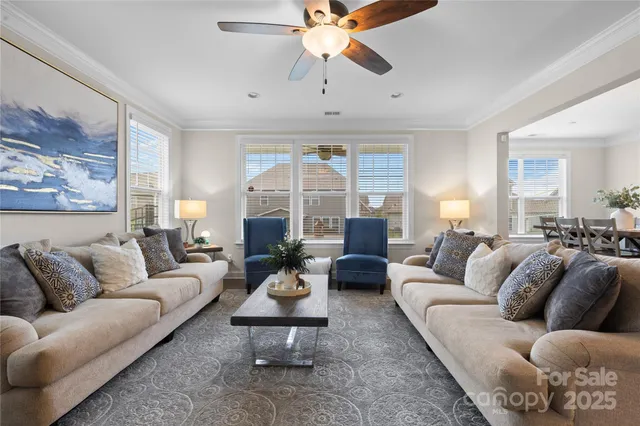 a living room with furniture a fireplace and a chandelier