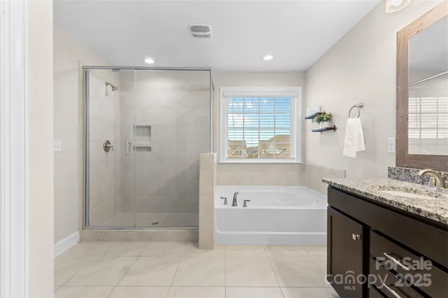 a bathroom with a granite countertop sink a mirror and a bathtub
