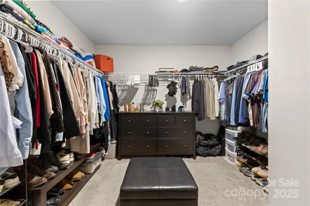 a view of walk in closet with clothes and shoes