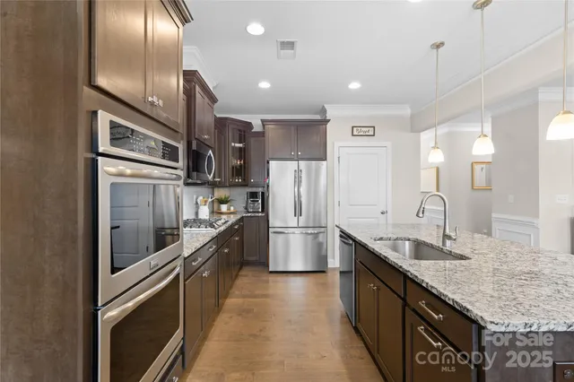 a large kitchen with granite countertop lots of counter space and stainless steel appliances