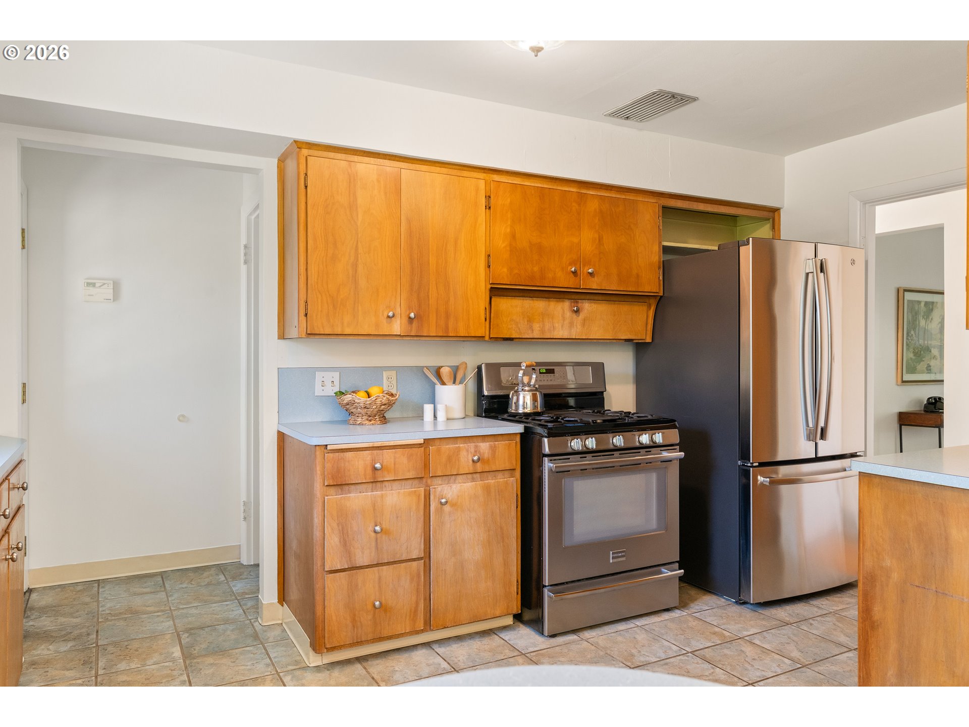 7541 Northeast Alameda Street Portland, OR 97213 - Photo 10 of 35 a kitchen with stainless steel appliances granite countertop a refrigerator a stove and a sink with wooden cabinets