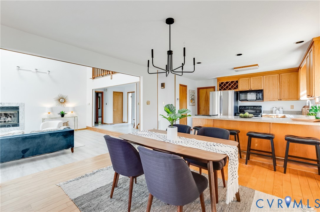 14722 Swift Water Road Chesterfield, VA 23838 - Photo 22 of 50 a dining room with stainless steel appliances granite countertop a kitchen island a stove a dining table and chairs with wooden floor