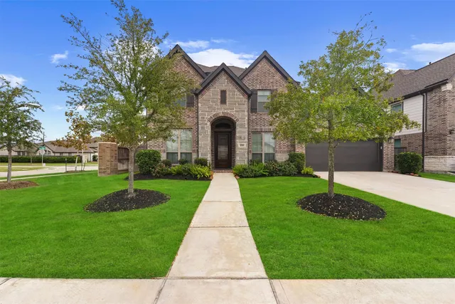 a front view of a house with a yard and a garden