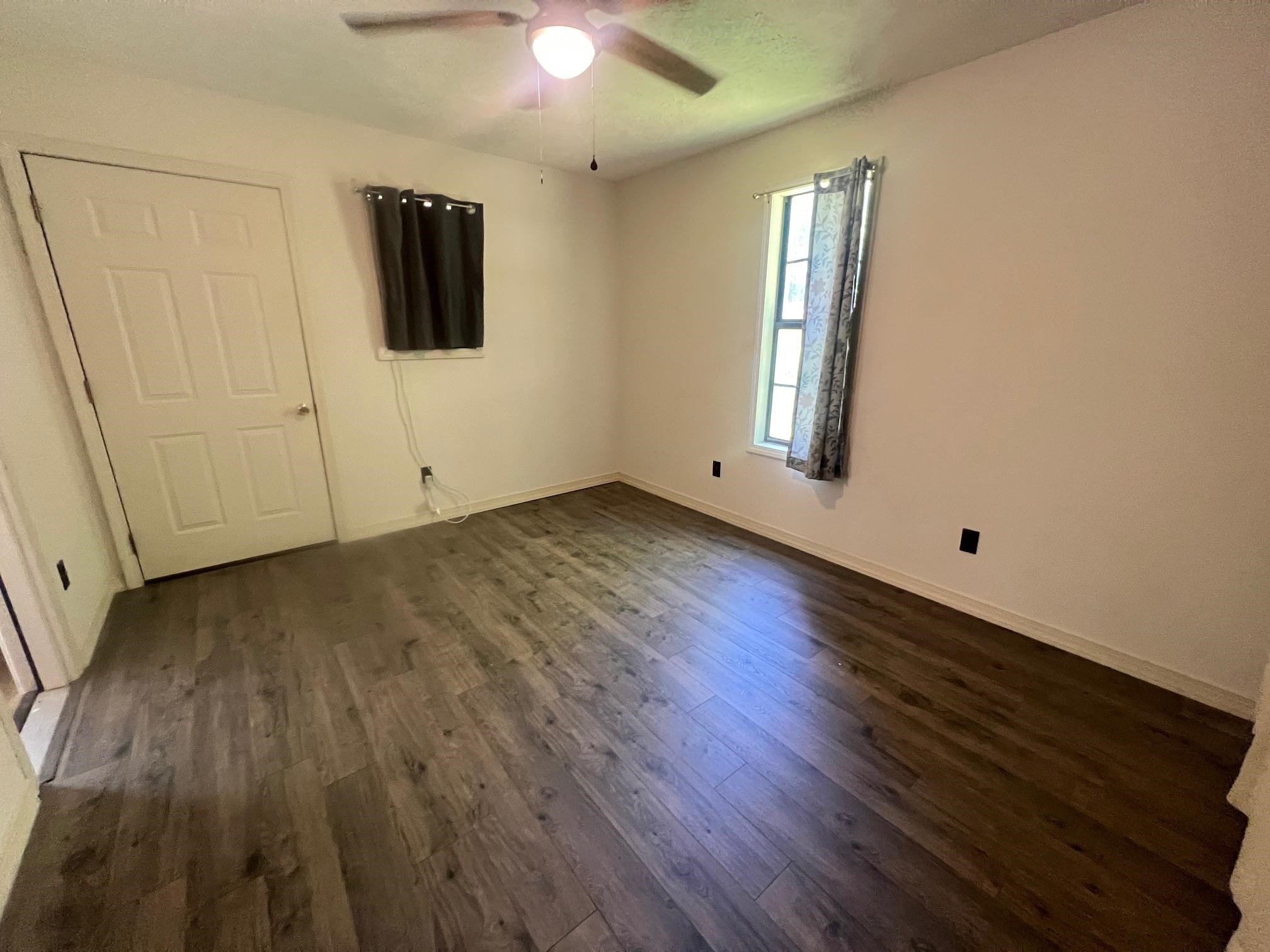 90 Double Springs Loop Savannah, TN 38372 - Photo 13 of 31 an empty room with wooden floor and windows