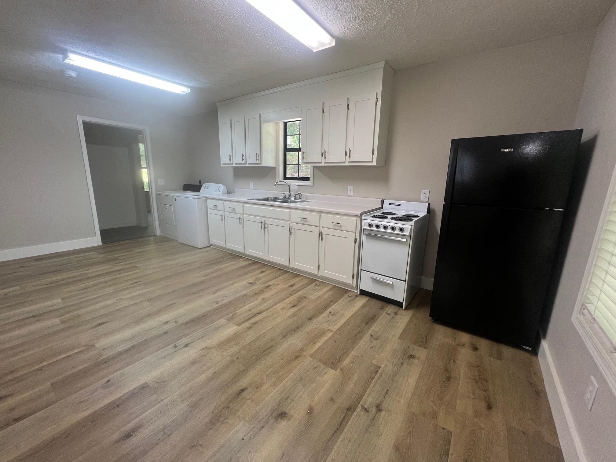 90 Double Springs Loop Savannah, TN 38372 - Photo 2 of 31 a kitchen with a sink a refrigerator and cabinets
