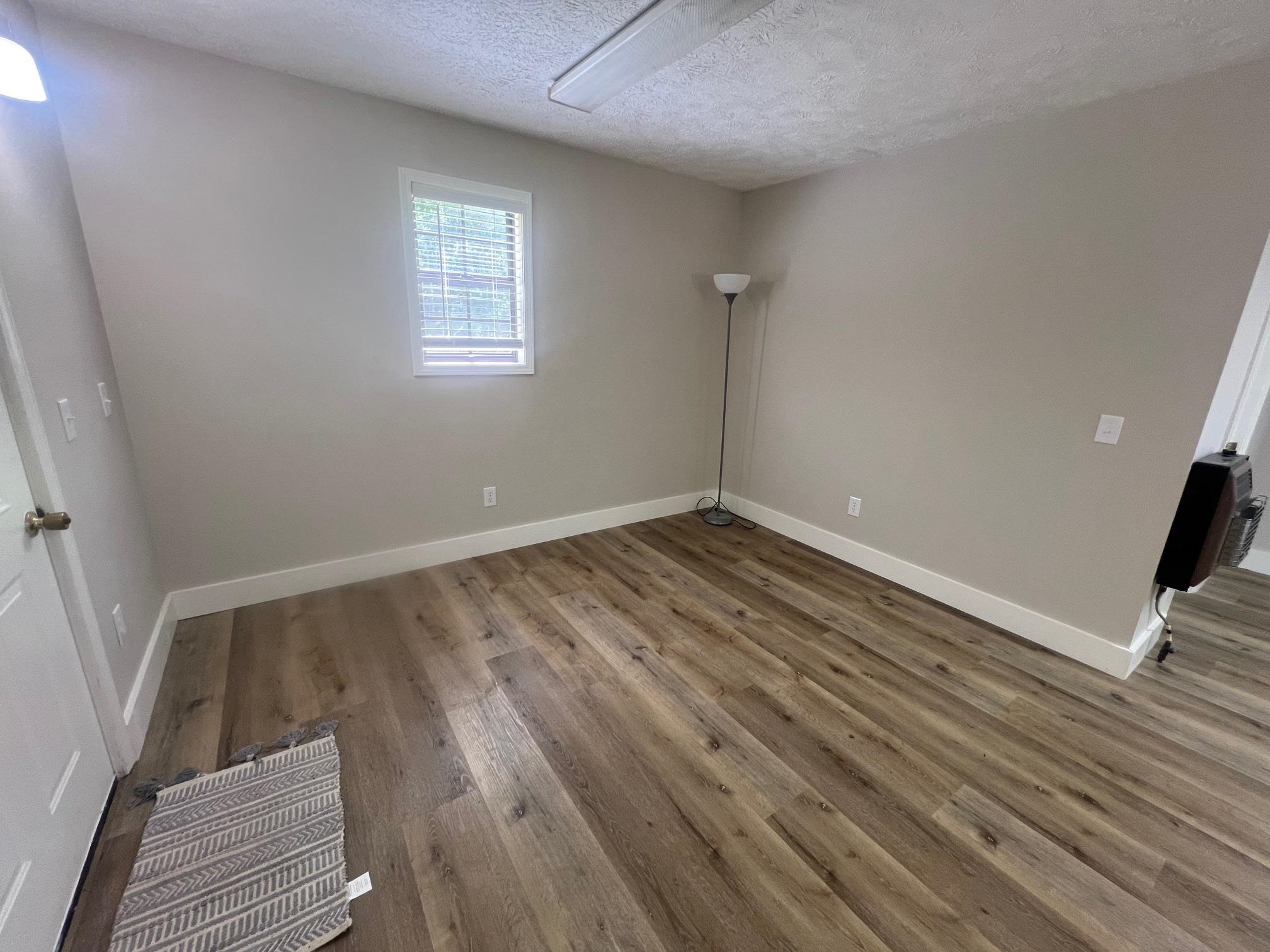 90 Double Springs Loop Savannah, TN 38372 - Photo 7 of 31 an empty room with wooden floor and windows