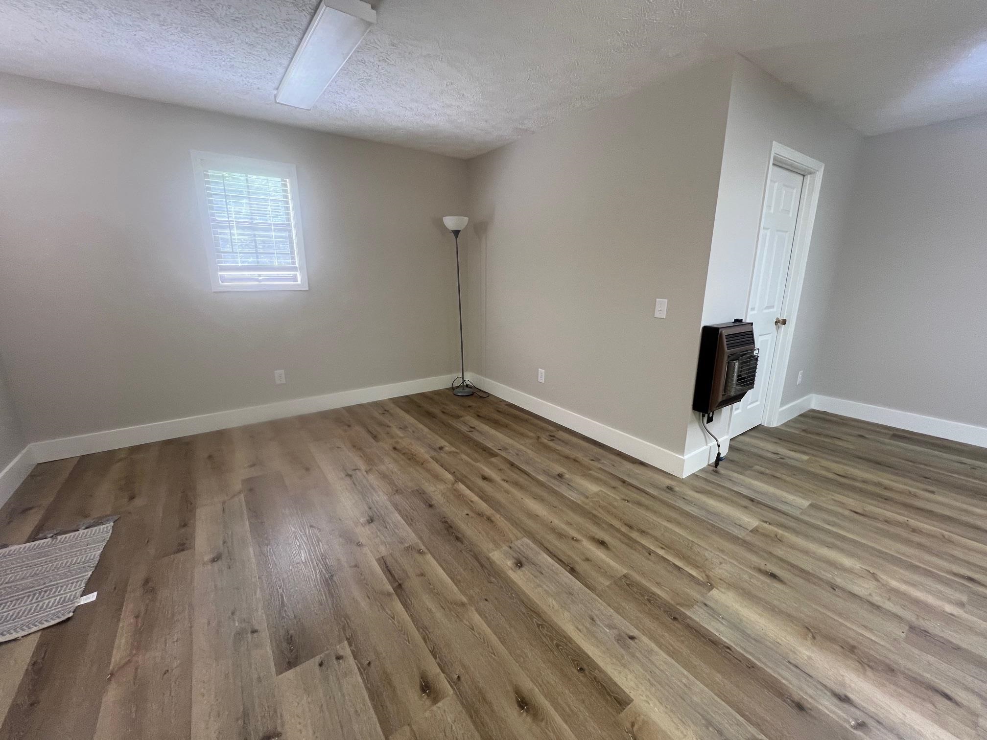 90 Double Springs Loop Savannah, TN 38372 - Photo 9 of 31 an empty room with wooden floor and windows