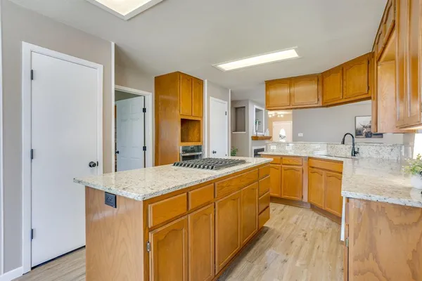 a large kitchen with stainless steel appliances granite countertop a sink and dishwasher a stove with wooden floors