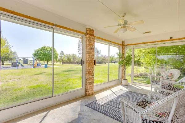 a living room with hardwood floor and large windows