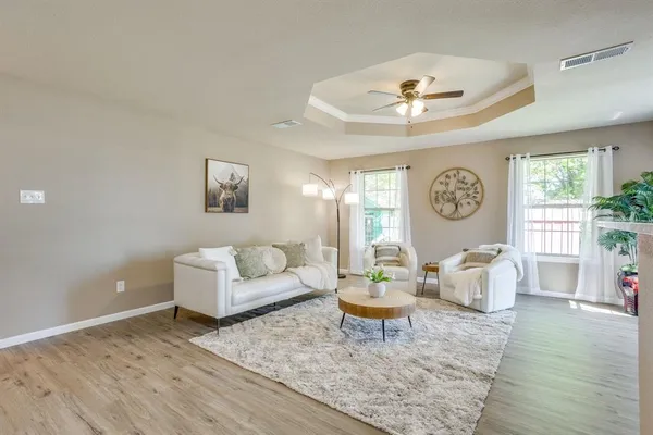 a living room with furniture and a wooden floor