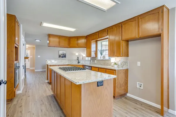 a kitchen with stainless steel appliances granite countertop a sink a stove and a refrigerator