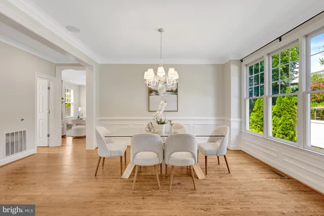 a view of a dining room with furniture a chandelier and wooden floor