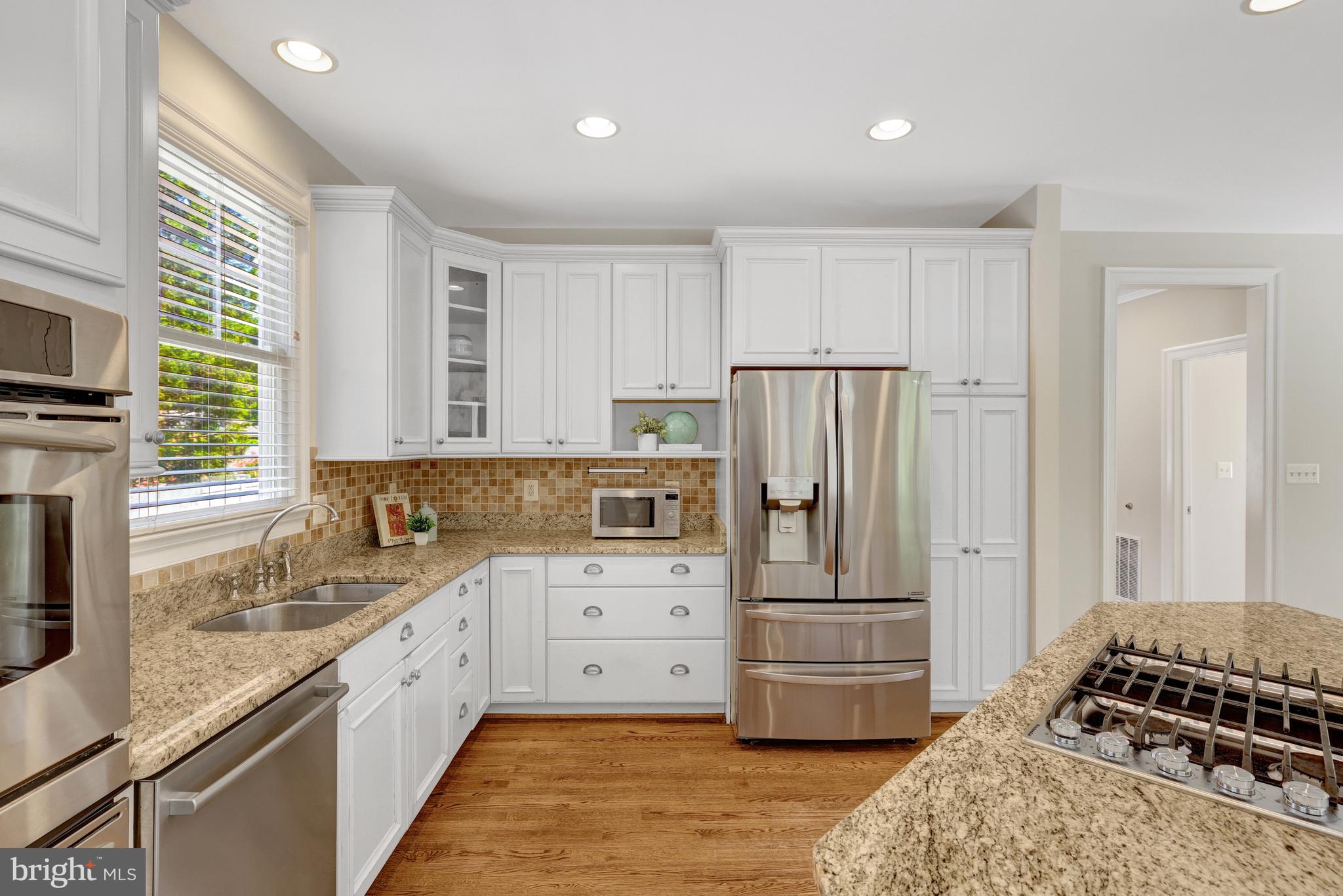 1519 Pathfinder Lane McLean, VA 22101 - Photo 21 of 54 a kitchen with kitchen island granite countertop a refrigerator stove and sink
