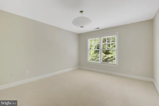 an empty room with window and ceiling fan