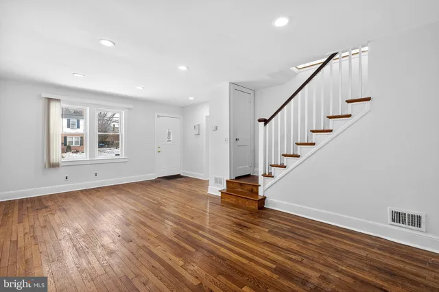 a view of empty room with wooden floor and window