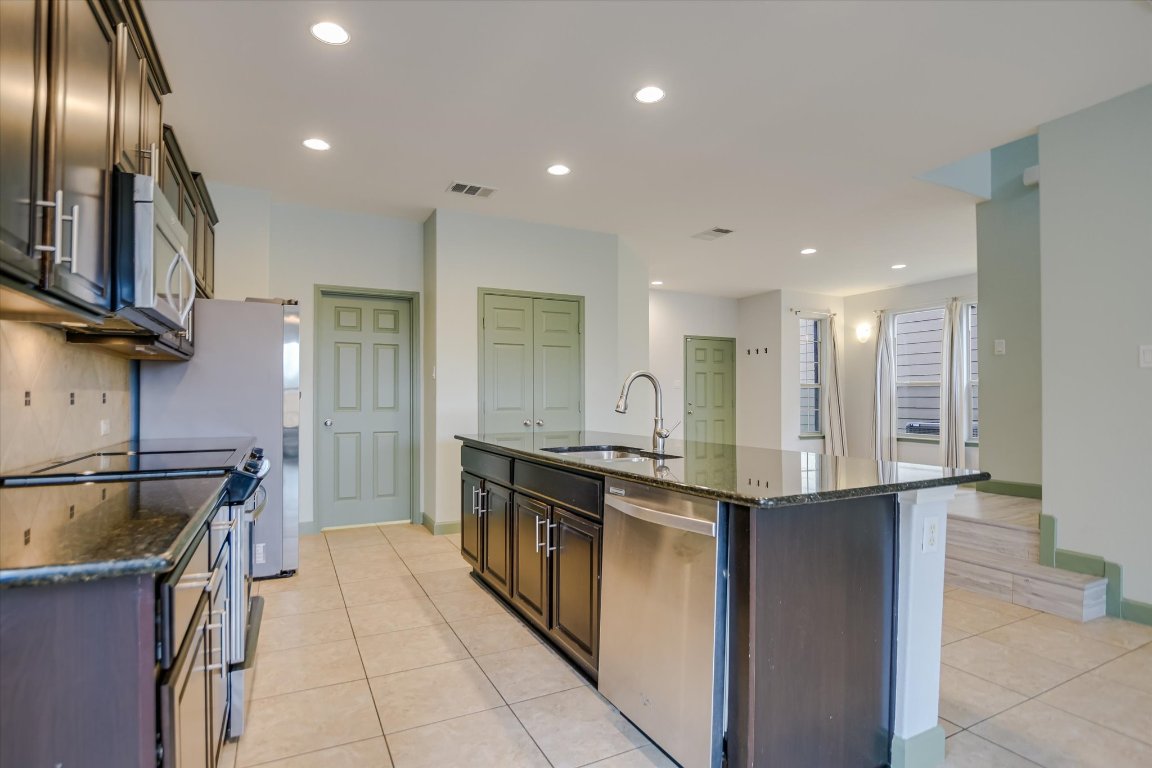 10020 Wading Pool Path Austin, TX 78748 - Photo 2 of 20 Kitchen featuring stainless steel appliances, granite counter tops, tiled flooring & recessed lighting.