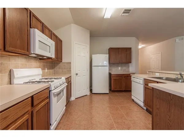 a kitchen with stainless steel appliances a stove microwave and a sink