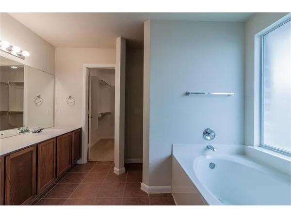 a bathroom with a tub sink and mirror