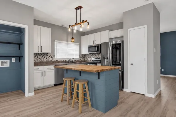 a kitchen with kitchen island granite countertop a sink cabinets and stainless steel appliances