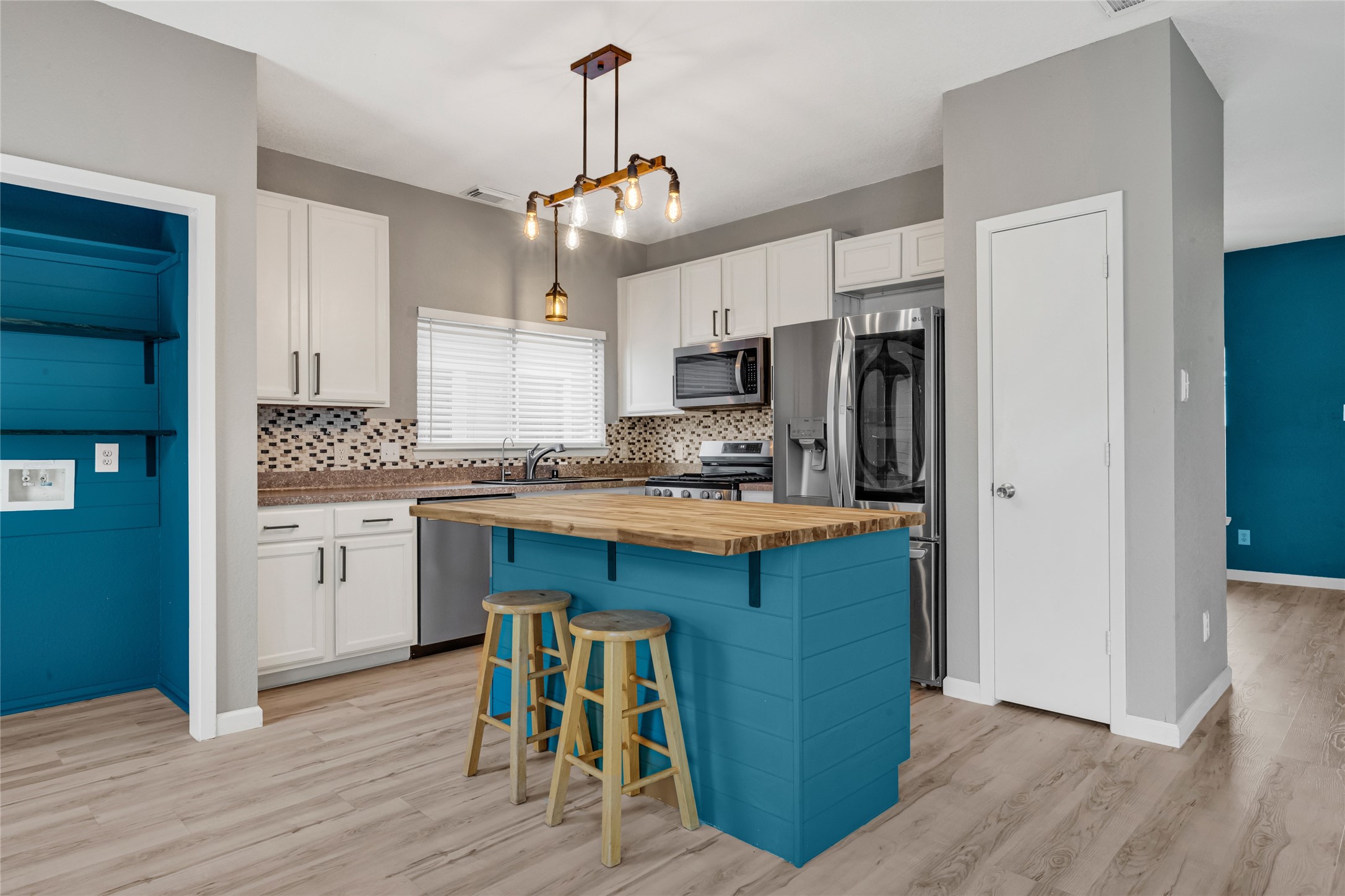 21831 Mossy Field Lane Spring, TX 77388 - Photo 6 of 26 a kitchen with granite countertop a refrigerator a stove a sink and white cabinets with wooden floor