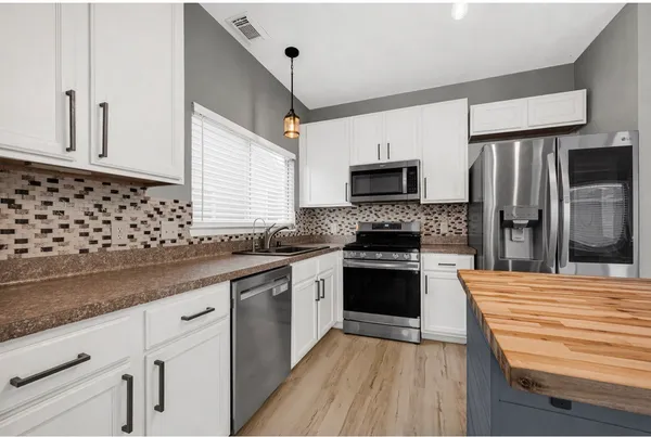 a kitchen with a refrigerator a sink dishwasher a stove and a refrigerator