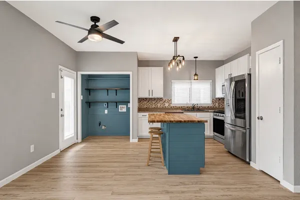 a view of a kitchen with wooden floor and a ceiling fan