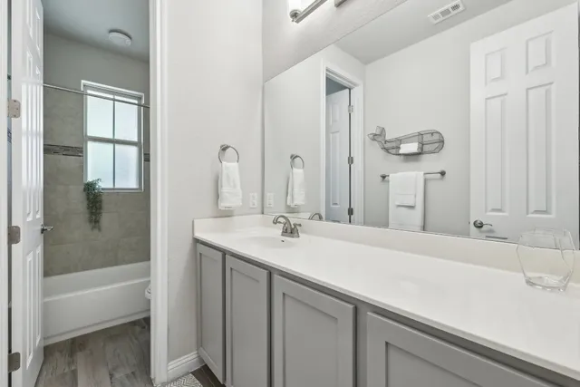 a bathroom with a sink and a mirror with bathtub