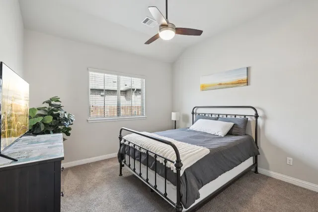 a bedroom with a bed window and a potted plant