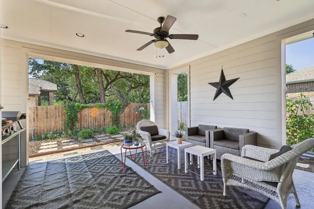 a living room with furniture a floor to ceiling window and a ceiling fan