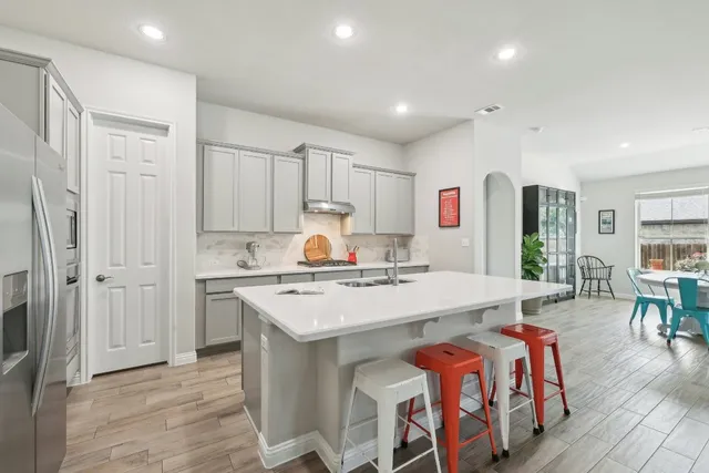 a open kitchen with stainless steel appliances granite countertop a stove and a refrigerator