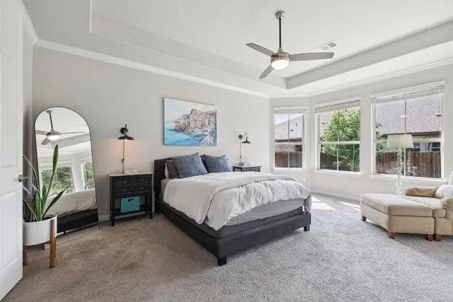 a spacious bedroom with a bed a couch and a large window