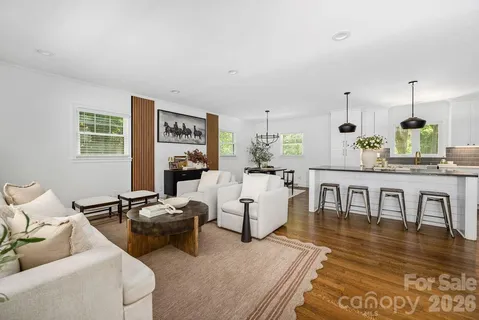 a living room with furniture wooden floor and a table