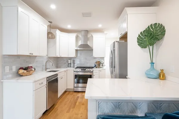 a kitchen with stainless steel appliances a sink a stove a refrigerator and cabinets