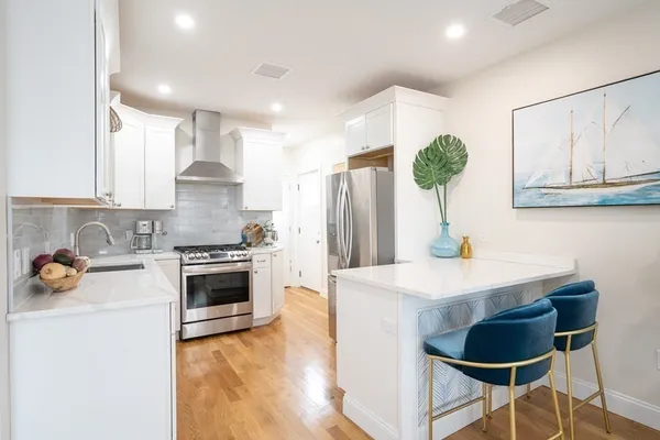 a kitchen with stainless steel appliances a table and chairs in it