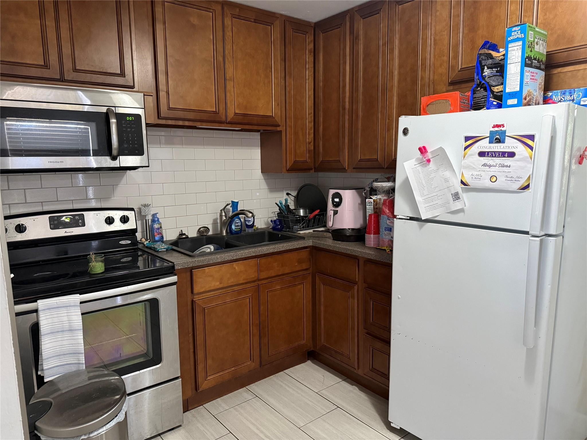 817 Southeast 9th Street Okeechobee, FL 34974 - Photo 11 of 13 a white kitchen with wooden cabinets and stainless steel appliances