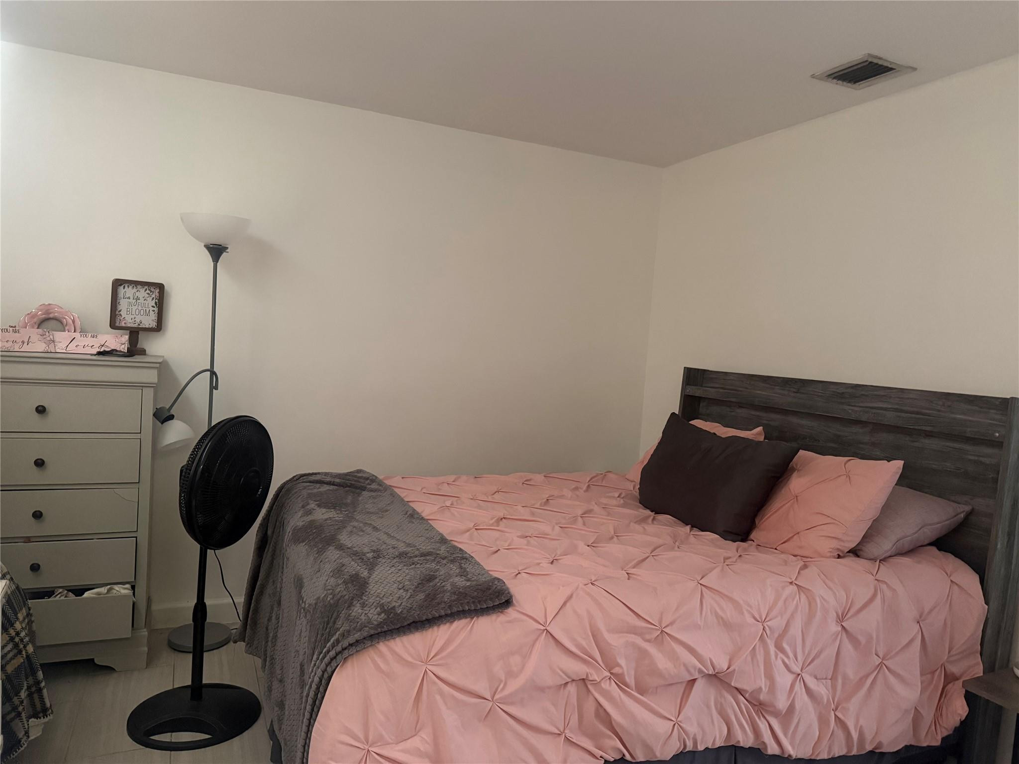 817 Southeast 9th Street Okeechobee, FL 34974 - Photo 3 of 13 a bedroom with a bed and a chair