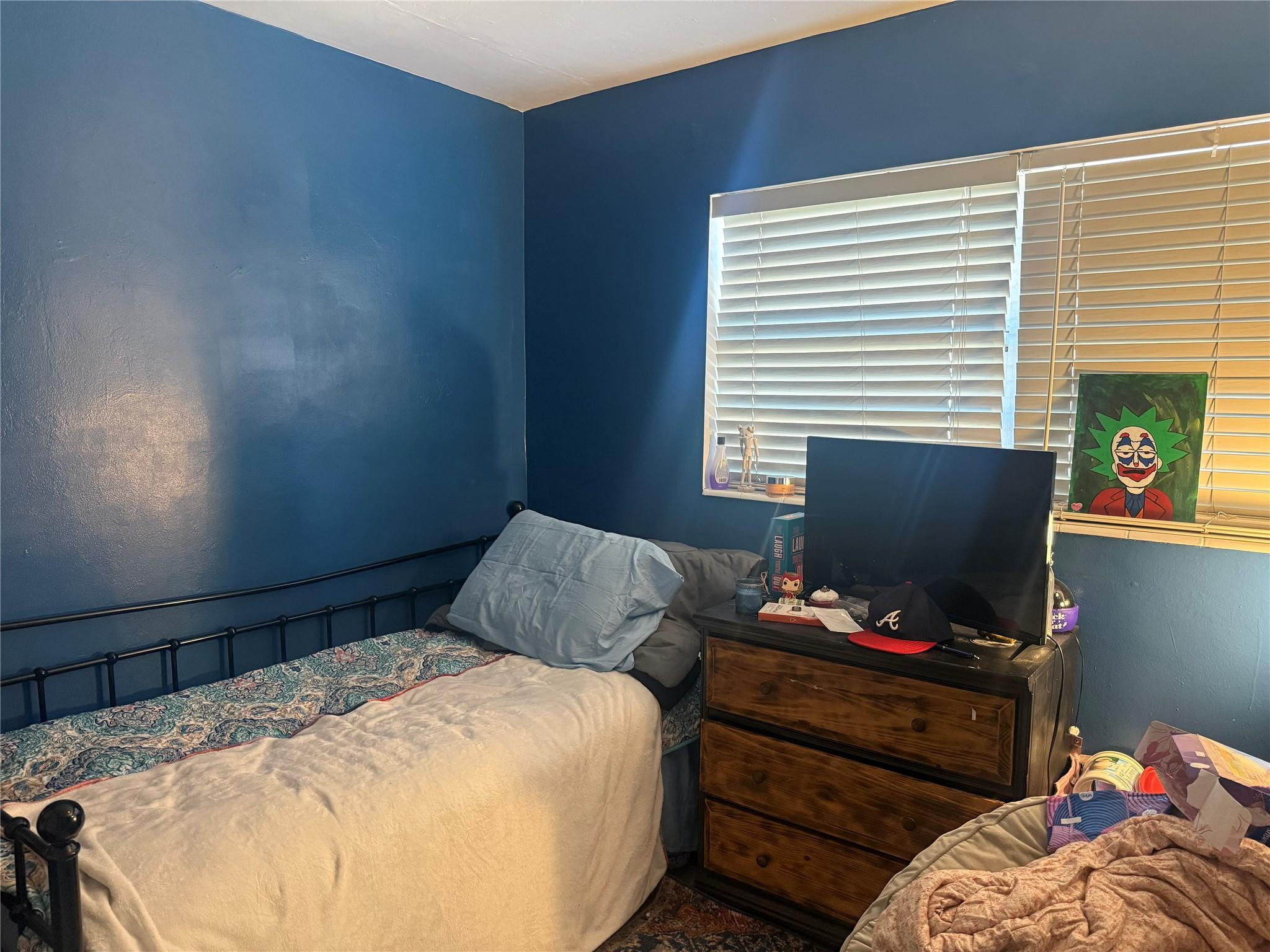 817 Southeast 9th Street Okeechobee, FL 34974 - Photo 5 of 13 a bedroom with a bed and a flat screen tv