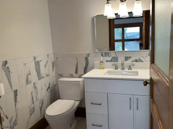 a bathroom with a sink vanity mirror and toilet