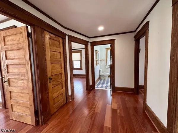 a view of hallway with wooden floor and stairs