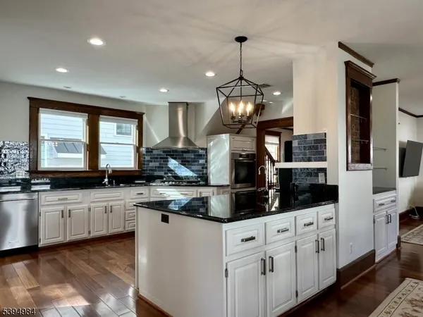 a kitchen with stainless steel appliances granite countertop a sink a stove and cabinets