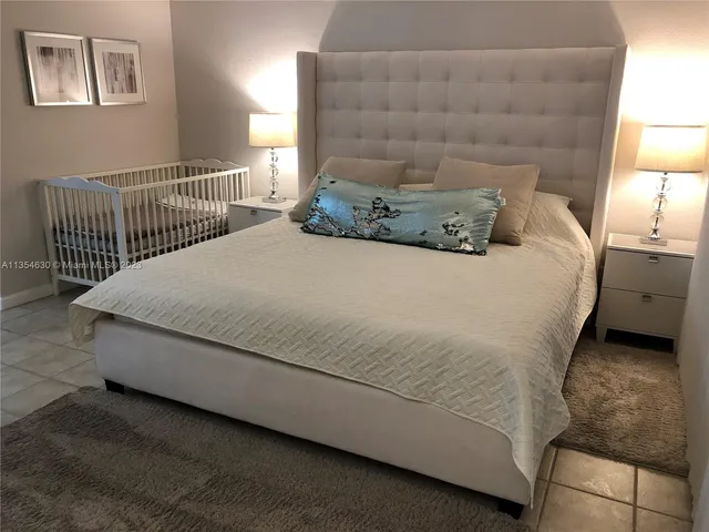 a bed sitting in a bedroom next to a lamp