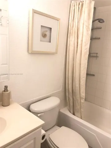 a white toilet sitting next to a bathroom sink and a shower