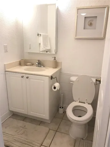 a bathroom with a toilet a sink and mirror