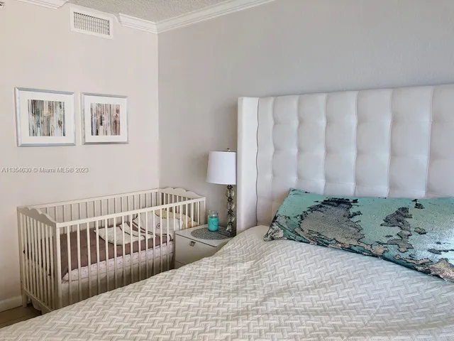 a bedroom with a bed and painting on the wall