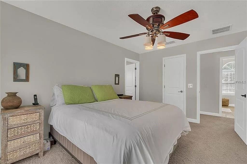 5526 Tiny Road Winter Garden, FL 34787 - Photo 20 of 39 a bedroom with a bed and a chandelier