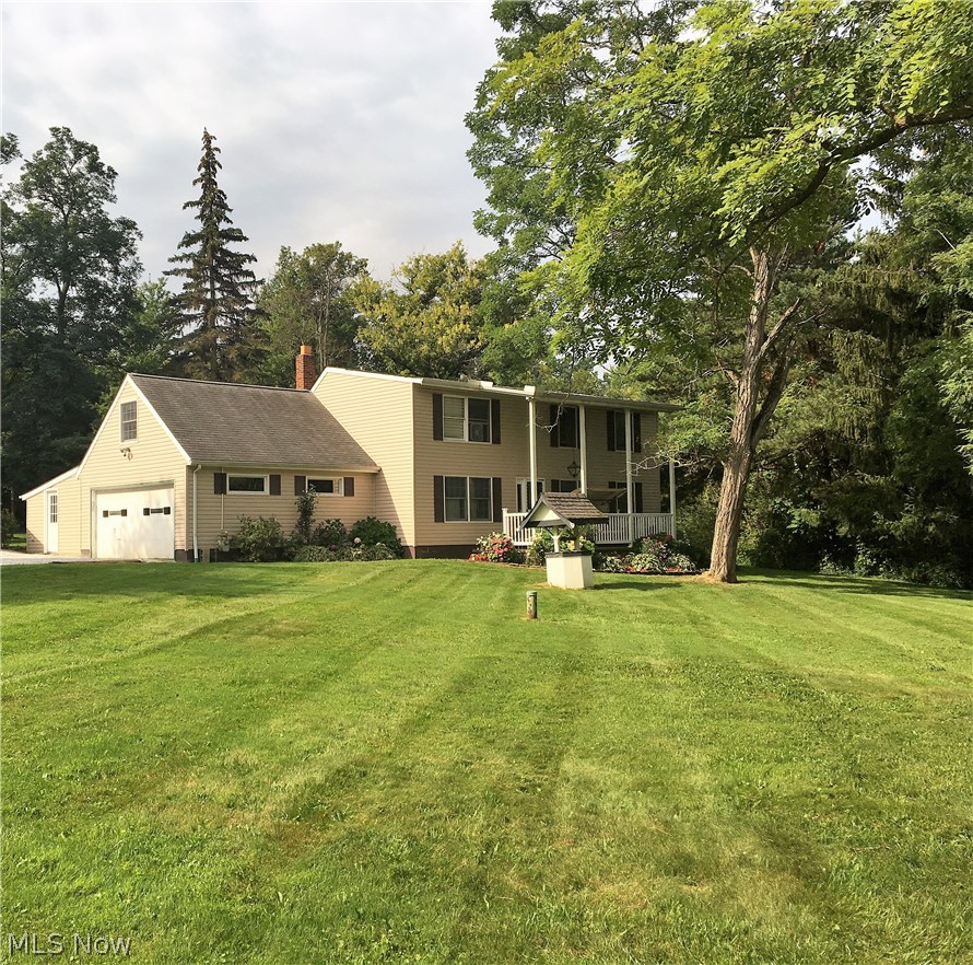 Stately colonial sets well back from the road on a lightly wooded, park-like setting.