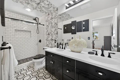 a spacious bathroom with double sink and a mirror