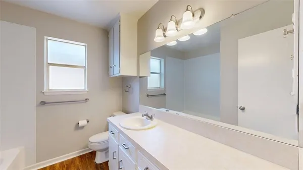 a bathroom with a sink a toilet and a mirror