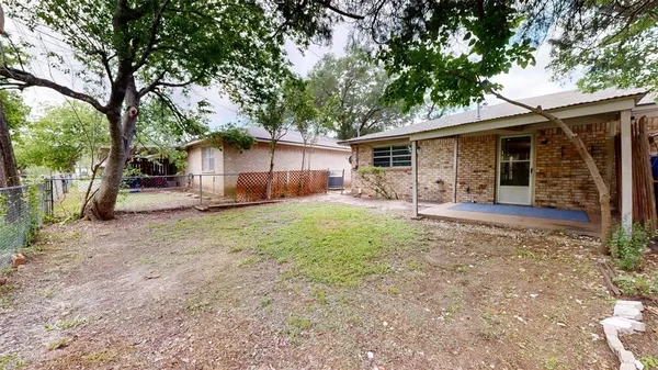 front view of a house with a yard and an trees